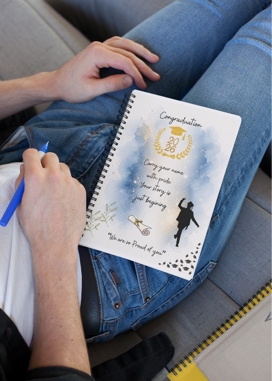 Person sitting on a couch with a spiral-bound notebook and pen, wearing blue jeans.